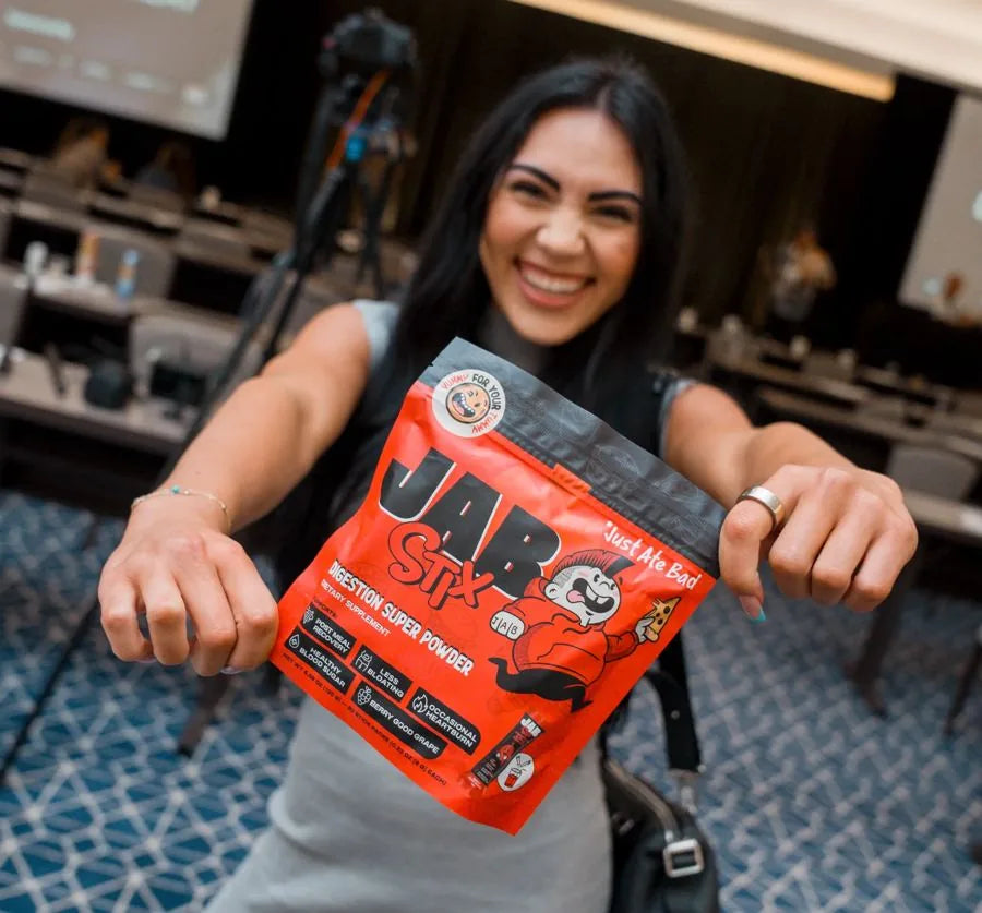 Smiling woman holding a pouch of JAB Stix
