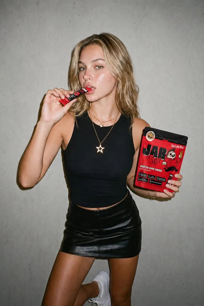 A woman with a JAB Stix in her teeth, holding the pouch